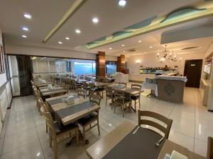 une salle à manger avec des tables et des chaises dans un restaurant dans l'établissement Grand Anzac Hotel, à Çanakkale