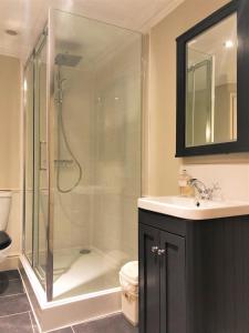 a bathroom with a glass shower and a sink at Ivory House - Stunning Central Townhouse in Bath