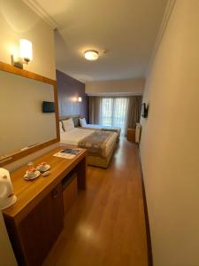 a hotel room with a bed and a large mirror at Grand Anzac Hotel in Çanakkale