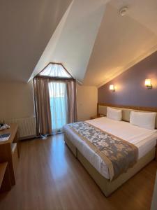 a bedroom with a large bed and a window at Grand Anzac Hotel in Çanakkale