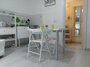 eine Küche mit einem Tisch und zwei weißen Stühlen in der Unterkunft AWroom in Riomaggiore