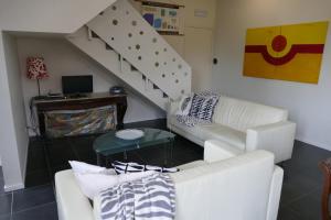 a living room with a couch and a staircase at De Oude School 4 pers app in Visé