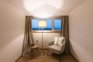 um quarto com uma cadeira, um candeeiro e uma janela em Rías Altas - Hotel Restaurante em Barreiros