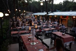 a group of people sitting at tables at a restaurant at Denizati Holiday Village in Gumuldur