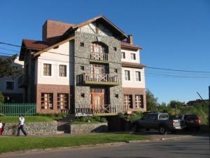 un homme qui passe devant une grande maison en briques dans l'établissement Acquamarina Hotel, à Villa Gesell