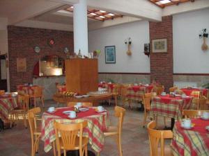 um restaurante com mesas e cadeiras com toalhas de mesa vermelhas e brancas em Acquamarina Hotel em Villa Gesell