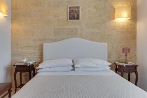 1 dormitorio con 1 cama blanca y 2 mesitas de noche en Le Lantane - Luxury Rooms, en Alessano
