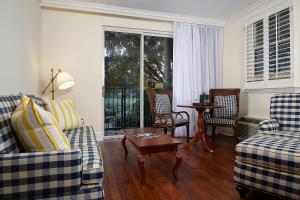 a living room with two couches and a table at Inn at Pelican Bay in Naples