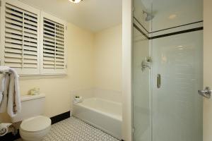 a bathroom with a toilet and a glass shower at Inn at Pelican Bay in Naples