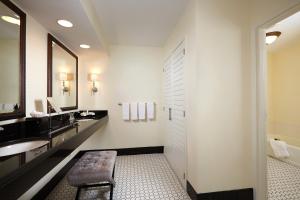 a bathroom with a sink and a bench in it at Inn at Pelican Bay in Naples