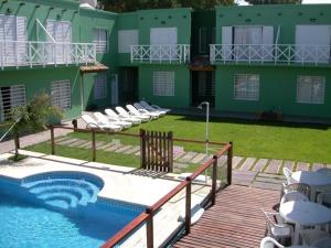 a building with a swimming pool in front of a house at Complejo Hueney in Mar de Ajó