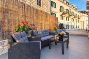 a patio with two chairs and a table with flowers at Lola Apartments - Hvar in Hvar