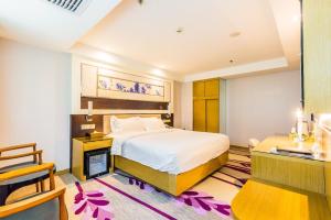 a hotel room with a bed and a desk and a room at Lavande Hotel Foshan Shunde Ronggui in Shunde