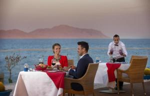 a man and a woman sitting at a table at Sunrise Arabian Beach Resort in Sharm El Sheikh