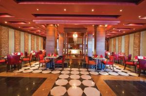 a restaurant with red chairs and tables in a room at Sunrise Arabian Beach Resort in Sharm El Sheikh