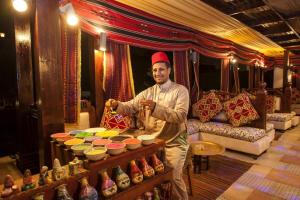 a man standing in front of a table with bowls at Sunrise Arabian Beach Resort in Sharm El Sheikh