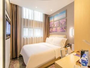 a bedroom with a bed and a desk and a window at Lavande Hotel Suzhou Shilu Changxu in Suzhou