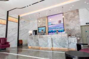 a lobby with a large stone wall with a reception desk at Lavande Hotels·Dalian Xinghai Park in Dalian