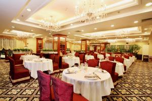 a restaurant with white tables and chairs and chandeliers at Grand Palace Hotel - Grand Hotel Management Group in Guangzhou