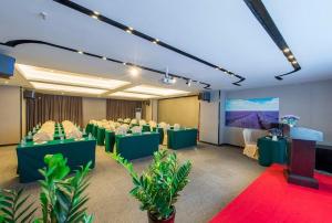 a conference room with green tables and chairs and a screen at Lavande Hotel (Foshan Nanhai Square) in Foshan