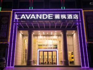 un frente de tienda con un cartel púrpura iluminado en Lavande Hotels·Sanya Pedestrian Street en Sanya