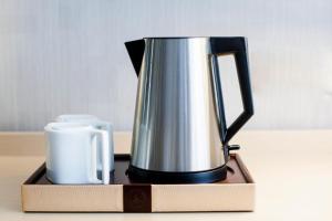 a coffee pot and a mug on a table at Lavande Hotels·Sanya Pedestrian Street in Sanya