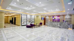 a lobby of a hotel with purple chairs and a counter at Lavande Hotel Chengdu Dafeng Shixi Park Subway Station in Chengdu