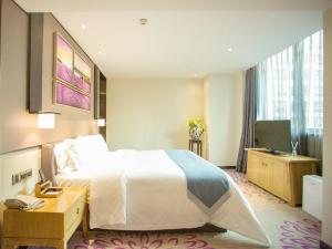 a hotel room with a bed and a desk and a television at Lavande Hotels·Guangzhou East Railway Station in Guangzhou