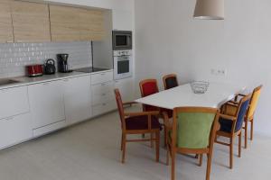 uma cozinha com uma mesa branca e cadeiras em Apartmány Stříbro em Stříbro
