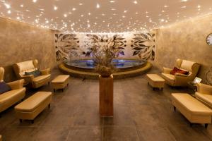 eine Lobby mit einem Brunnen, einem Tisch und Stühlen in der Unterkunft Hotel Zlaty Klucik - Golden Key with Luxury SPA in Nitra