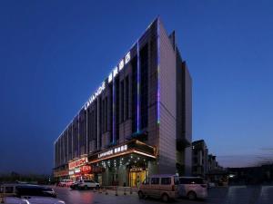 a large building with cars parked in a parking lot at Lavande Hotel (Tianjin Zhongbei Avenue) in Tianjin