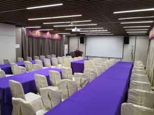 una sala conferenze con tavoli viola e sedie bianche di Lavande Hotels·Guangzhou Dongpu Bus Terminal a Canton