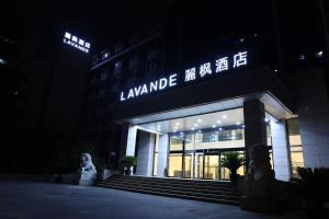 un edificio iluminado con escaleras delante por la noche en Lavande Hotels·Beijing South Railway Station Yangqiao en Pekín