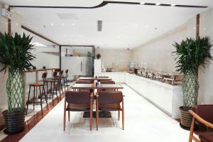 a restaurant with wooden tables and chairs and plants at Lavande Hotels·Beijing South Railway Station Yangqiao in Beijing
