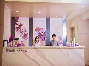 a man and woman standing behind a counter in a bathroom at Lavande Hotel Xi'an Bell Tower in Xi'an