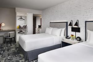 a hotel room with two beds and a desk at Hyatt Centric Old Town Alexandria in Alexandria