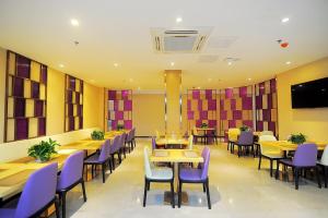 a dining room with tables and purple chairs at Lavande Hotel Gulin railway station Shangzhi Alley in Guilin