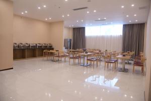 a dining room with tables and chairs in a room at Lavande Hotels·Foshan Lishui Heshun Wanfu City in Foshan