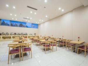 a dining room with wooden tables and chairs at Lavande Hotels·Foshan Lishui Heshun Wanfu City in Foshan