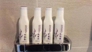 um grupo de quatro garrafas brancas sentadas numa prateleira em Lavande Hotels·Foshan Nanhai Dali New Metropolis em Foshan