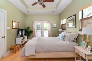 Un dormitorio con una cama y un ventilador de techo. en The Forest, en Austin