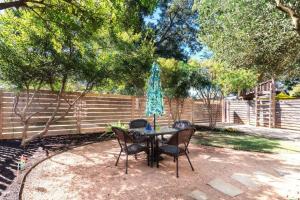 Una mesa y sillas con una sombrilla en un patio. en The Forest, en Austin