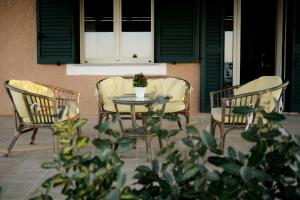 斯廷蒂諾的住宿－儂諾斯塔卡住宿加早餐旅館，庭院里摆放着三把椅子和一张桌子,上面放着盆子