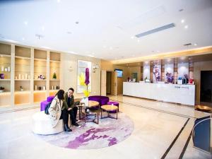 two people sitting on a couch in a lobby at Lavande Hotels·Taicang Shanghai West Road Nanyang Plaza in Suzhou