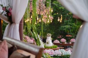 a table with a wedding cake and flowers at Estalagem Alter Real in Pirenópolis