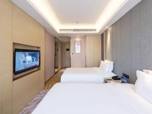 a hotel room with two beds and a tv at Lavande Hotel Beijing Railway Station in Beijing