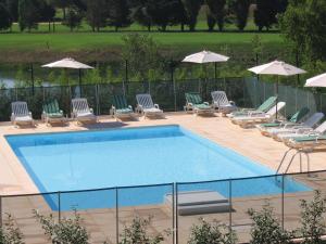 una piscina con tumbonas y sombrillas en Residhotel Golf Grand Avignon, en Vedène