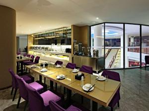 a restaurant with a long table and purple chairs at Lavande Hotels·Guilin Central Square Elephant Trunk Hill Scenic Area in Guilin