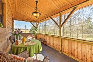 a room with a table and chairs in a cabin with windows at Honey House Cabin - A Quiet Countryside Retreat! in Nappanee