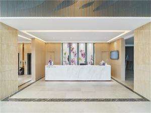 a lobby with a reception desk in a building at Lavande Hotels·Foshan West Railway Station Luocun in Foshan